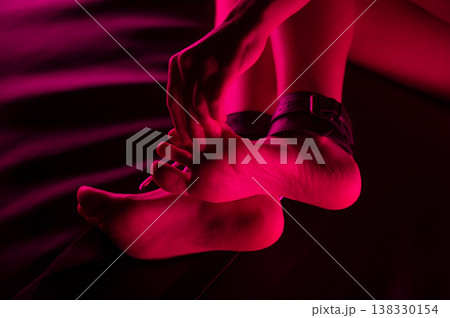 Women's legs in leather shackles. BDSM fetish. 138330154