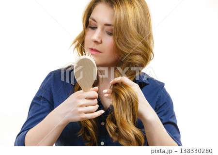 Woman brushing long healthy brown hair 138330280