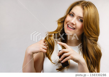 Woman applying hair cosmetic 138330286