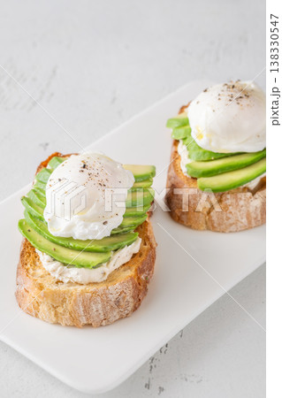 Avocado toast with poached eggs on artisan bread plate Avocado toast with poached eggs on artisan bread plate 138330547