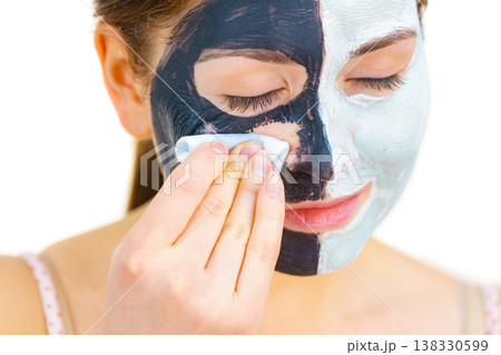 Girl remove black white mud mask from face 138330599