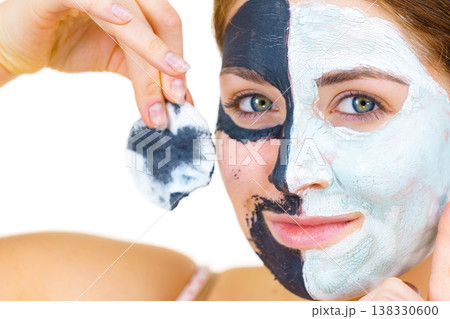 Girl remove black white mud mask from face 138330600