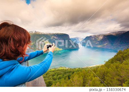 Tourist taking photo from Stegastein viewpoint Norway Tourist taking photo from Stegastein viewpoint Norway 138330674