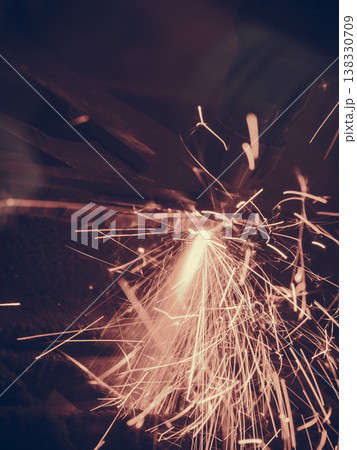 Laser cutting steel metal with bright sparks 138330709