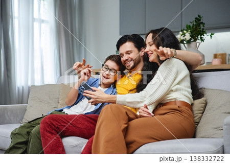 Family enjoying quality time together while watching videos at home Family enjoying quality time together while watching videos at home 138332722