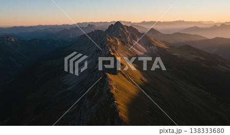 Aerial View Of Mountain Range At Sunset With Golden Sunlight And City Backdrop 138333680