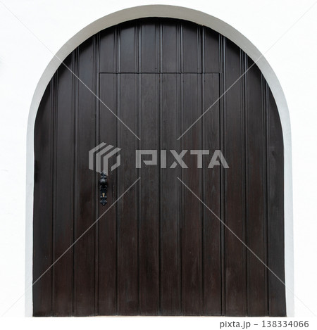 Arched Dark Wooden Door on White Wall Arched Dark Wooden Door on White Wall 138334066