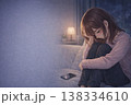 「スマホを見て落ち込む女性 恋愛 既読スルー 悩み 夜 イメージ 138334610