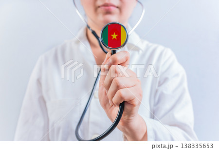 Female doctor holding stethoscope with Cameroon flag. National health system of Cameroon Female doctor holding stethoscope with Cameroon flag. National health system of Cameroon 138335653