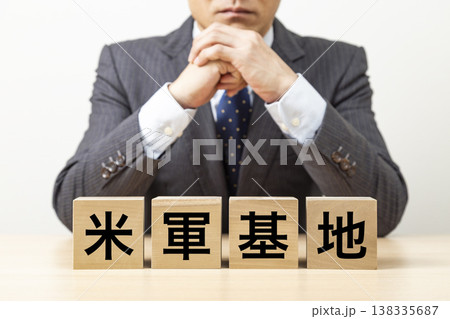 「米軍基地」と書かれたブロックとビジネスマン 138335687