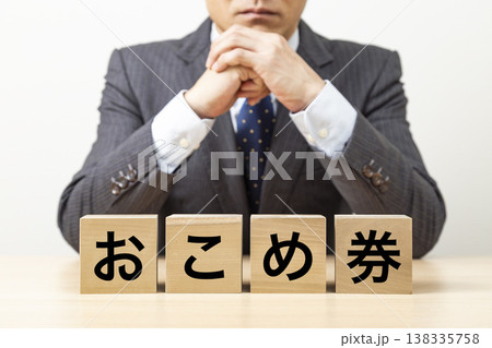 「おこめ券」と書かれたブロックとビジネスマン 138335758