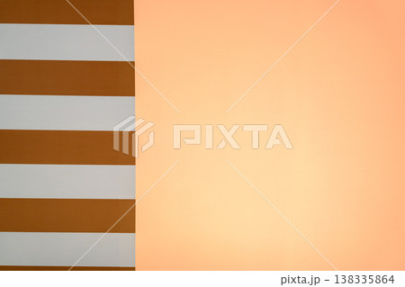 Abstract architectural Minimalist abstract background with a vertical split between orange and white horizontal stripes and a solid peach colored surface. Clean modern graphic design with copy space 138335864