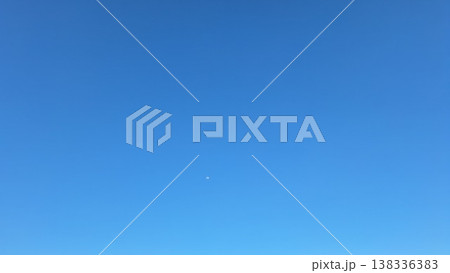 Minimalist Clear Blue Sky Background with Small Moon Shining in Bright Daylight Minimalist Clear Blue Sky Background with Small Moon Shining in Bright Daylight 138336383