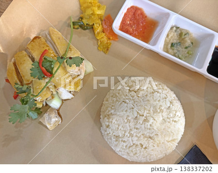 Delicious Hainanese chicken rice served with fragrant rice and dipping sauces 138337202