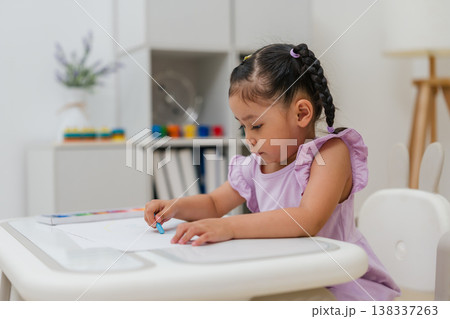 preschool child girl drawing and painting with colorful oil pastels on paper 138337263