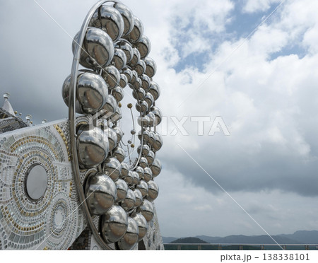 Silver sphere sculpture temple detail, modern religious architecture under cloudy sky 138338101