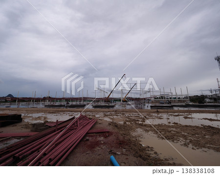 Construction site muddy ground steel pipe crane cloudy sky frame construction with crane muddy Construction site muddy ground steel pipe crane cloudy sky frame construction with crane muddy 138338108