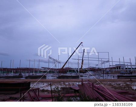 Construction site steel structure crane framework industrial muddy ground evening sky development Construction site steel structure crane framework industrial muddy ground evening sky development 138338109