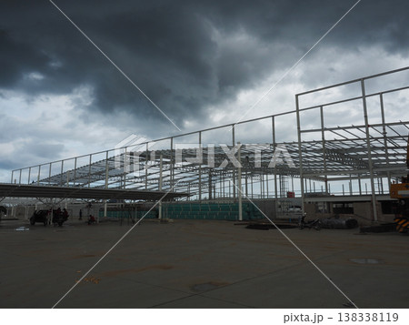 Industrial construction steel structure warehouse frame dark storm cloud wide angle view 138338119