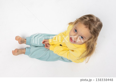 Portrait of beautiful cute little toddler girl. Child with funny face in yellow sweatshirt. Pretty smile kid in studio on white background. High quality photo Portrait of beautiful cute little toddler girl. Child with funny face in yellow sweatshirt. Pretty smile kid in studio on white background. High quality photo 138338448