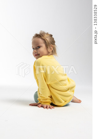 Portrait of beautiful cute little toddler girl. Child with funny face in yellow sweatshirt. Pretty smile kid in studio on white background. High quality photo Portrait of beautiful cute little toddler girl. Child with funny face in yellow sweatshirt. Pretty smile kid in studio on white background. High quality photo 138338529