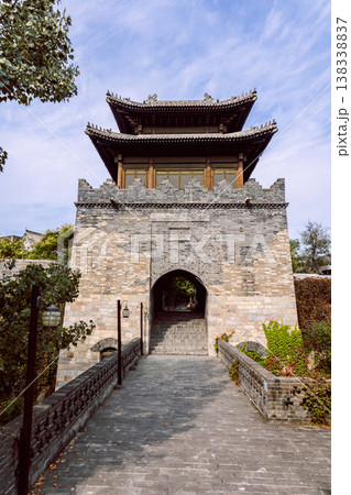 Gubei Water Town stone gate tower built of gray stone with elevated pavilion and walkway creating traditional Chinese town atmosphere in China Gubei Water Town stone gate tower built of gray stone with elevated pavilion and walkway creating traditional Chinese town atmosphere in China 138338837