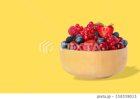 Bowl filled with red and blue berries on a bright background Bowl filled with red and blue berries on a bright background 138339013
