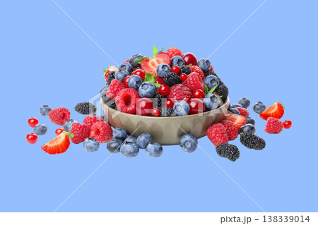 Bowl of assorted strawberries and blueberries on blue 138339014