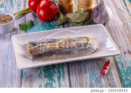 Marinated herring fillets with fresh vegetables and spices on a rustic wooden background 138339343