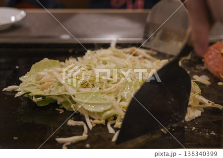 鉄板でもんじゃ焼きの具材を焼く様子　キャベツの調理風景 138340399