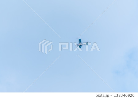 Small ultralight airplane with overhead wing and single propeller flying in sunset sky. Small ultralight airplane with overhead wing and single propeller flying in sunset sky. 138340920