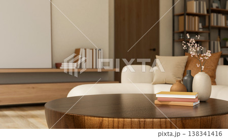 Books and flower vase on round wooden table and sofa across the door and bookshelf in a modern room. Books and flower vase on round wooden table and sofa across the door and bookshelf in a modern room. 138341416
