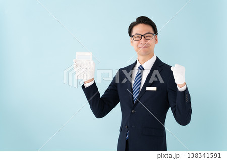 白手袋で計算機を持つ男性　ガッツポーズ 138341591