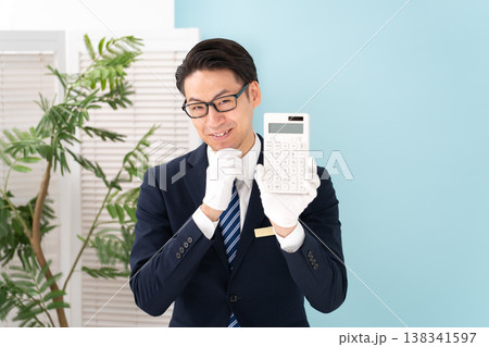 白手袋で電卓を持つ男性 138341597