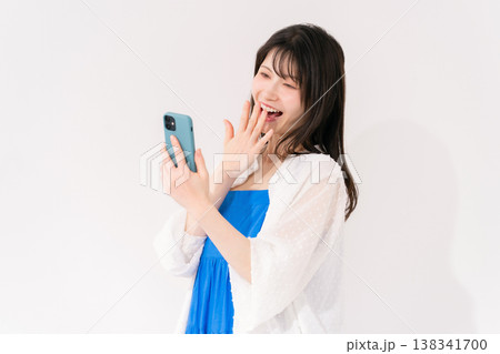 スマートフォンを持つ女性　驚く 138341700