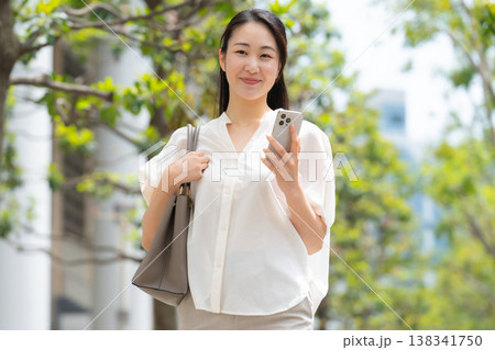 女性　カジュアル　初夏　歩く　スマホ 138341750