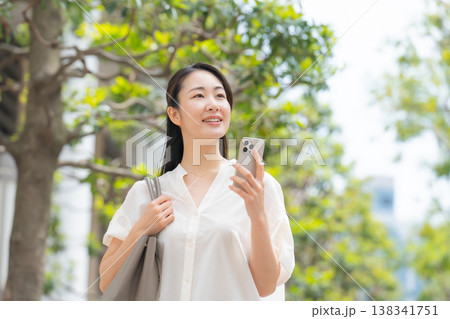 女性　カジュアル　初夏　歩く　スマホ 138341751