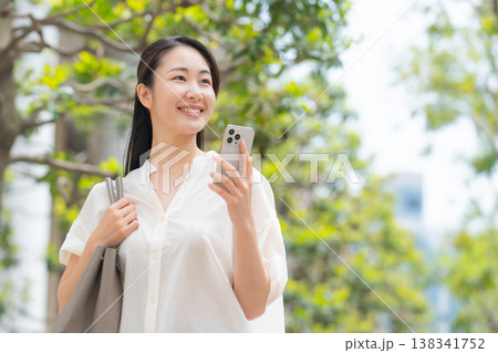 女性　カジュアル　初夏　歩く　スマホ 138341752