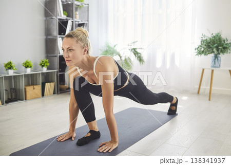 Slim woman having workout at home, exercising on fitness mat, practicing yoga Slim woman having workout at home, exercising on fitness mat, practicing yoga 138341937