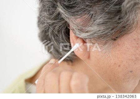 綿棒で耳掃除をするシニア女性 綿棒で耳掃除をするシニア女性 138342063