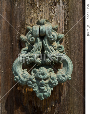 Antique bronze door knocker with a demonic face and gothic patterns Antique bronze door knocker with a demonic face and gothic patterns 138342590