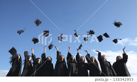 卒業を祝う東洋人女子大学生グループ、青空の下で角帽を投げる歓喜の瞬間 138342955