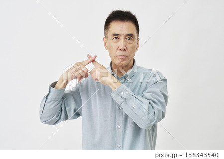 白背景でバツ印のジェスチャーをする男性 138343540