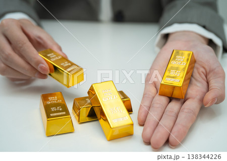 Asian woman holding gold bar in finance business. Asian woman holding gold bar in finance business. 138344226
