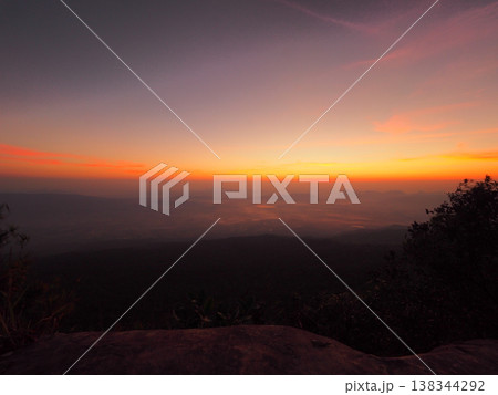 Sunrise dawn mountain valley silhouette colorful sky glow over quiet mountain valley Sunrise dawn mountain valley silhouette colorful sky glow over quiet mountain valley 138344292