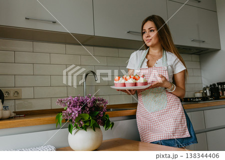 Woman preparing tasty Easter cupcake in kitchen Woman preparing tasty Easter cupcake in kitchen 138344406
