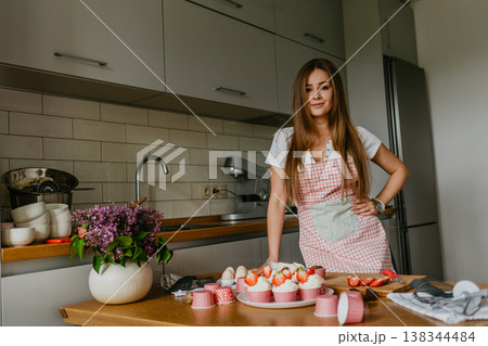 The action of making red velvet cupcakes. Woman hand adding sugar sprinkle on cupcake. The action of making red velvet cupcakes. Woman hand adding sugar sprinkle on cupcake. 138344484