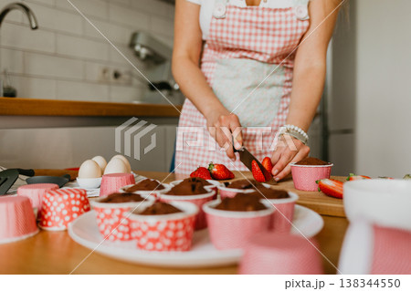 Young woman holding a fresh baked cupcake 138344550