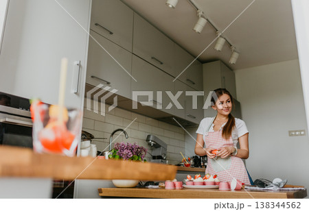 The action of making red velvet cupcakes. Woman hand piping cream cheese on cupcake. The action of making red velvet cupcakes. Woman hand piping cream cheese on cupcake. 138344562