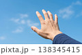 青空に手を伸ばす男性の手　希望・未来・自由のイメージ 138345415